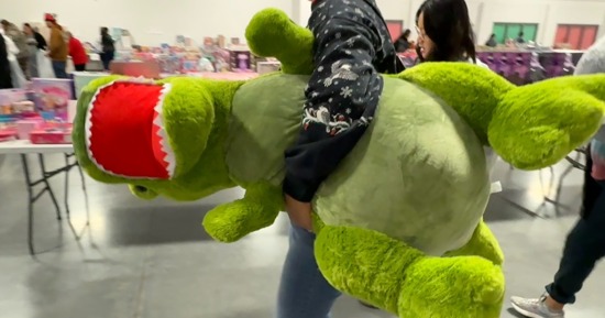 Toys for Tots 2025 Shopper carries dinosaur